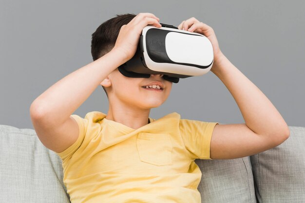 Niño sonriente con casco de realidad virtual