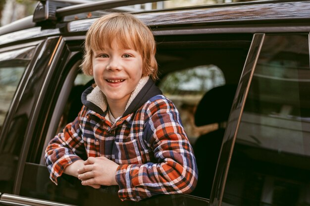 Niño sonriente en el coche durante un viaje por carretera