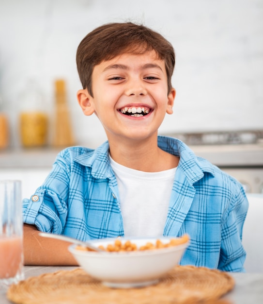 Niño sonriente desayunando en la mañana