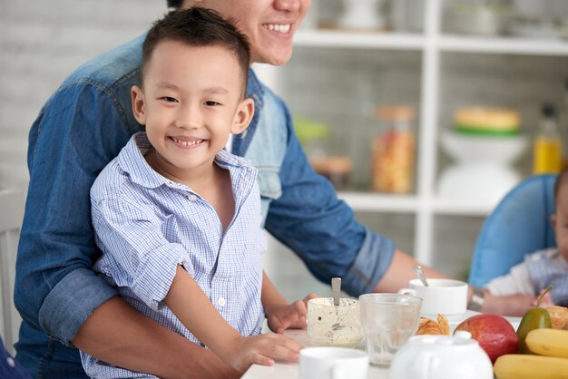 Niño sonriente en el desayuno con la familia