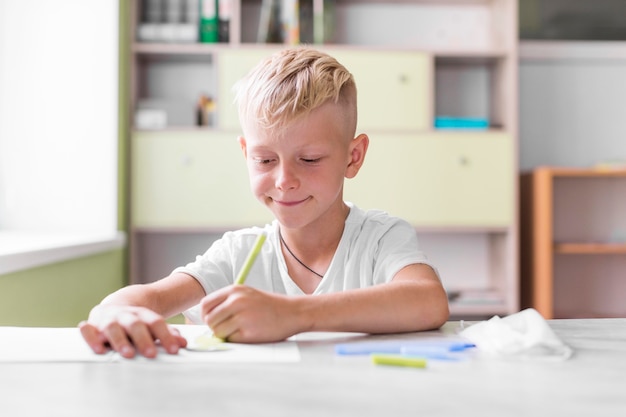 Niño sonriente escribiendo