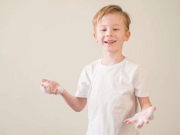 Niño sonriente con espuma en las manos