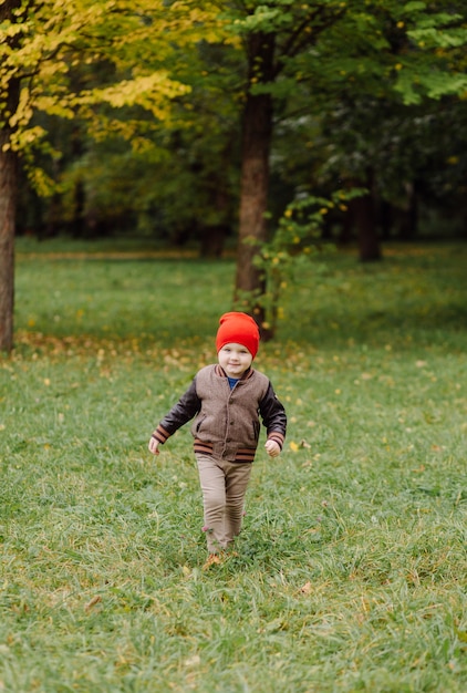 Niño sonriente feliz jugando al aire libre en un jardín.