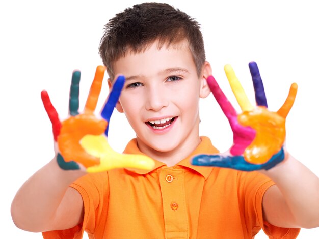 Niño sonriente feliz con manos pintadas aisladas en blanco.