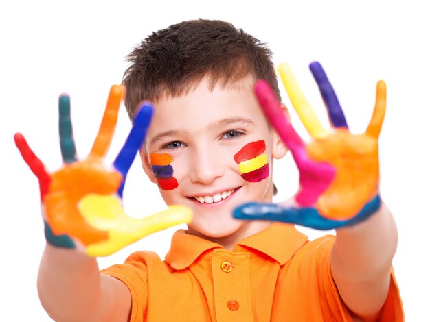 Niño sonriente feliz con las manos pintadas y la cara en camiseta naranja - en un espacio en blanco.
