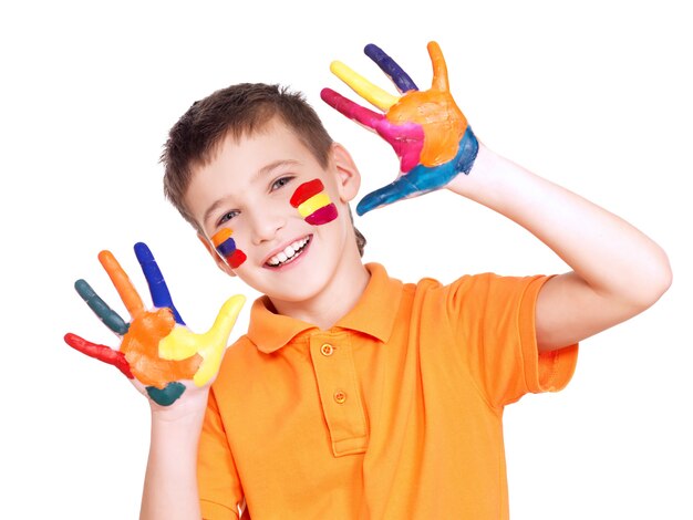 Niño sonriente feliz con las manos pintadas y la cara en camiseta naranja sobre blanco.