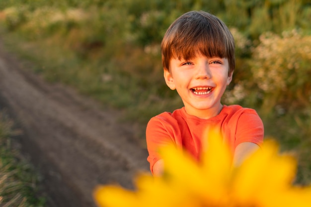 Niño sonriente con flor amarilla