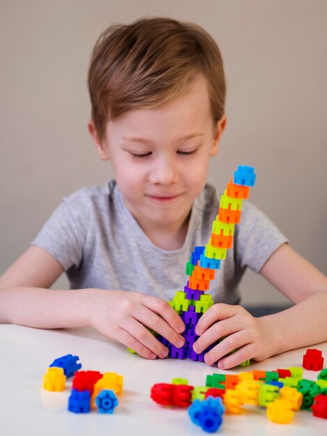 Niño sonriente jugando con colorido juego