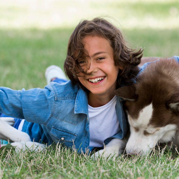 Niño sonriente jugando con su perro en el parque