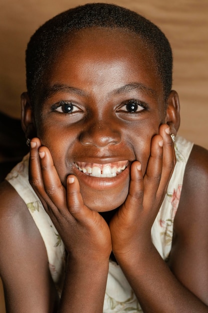 Foto gratuita niño sonriente con las manos y la cara