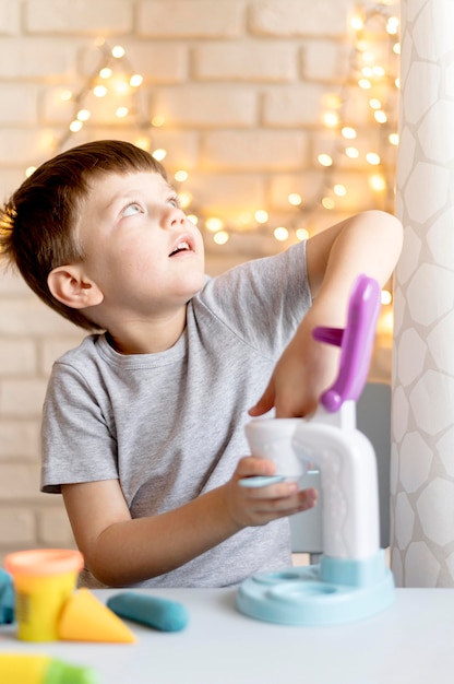 Foto gratuita niño sonriente con máquina de juguetes