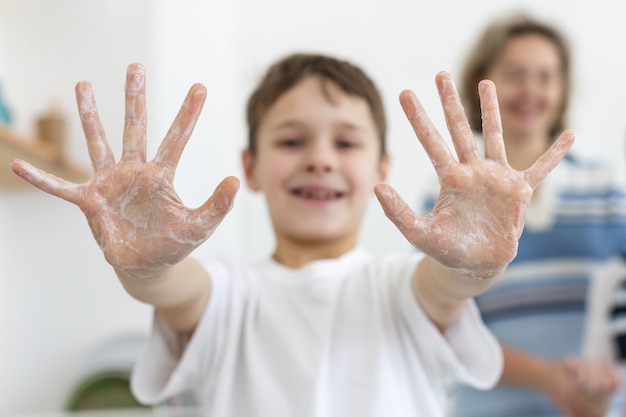Niño sonriente mostrando manos jabonosas