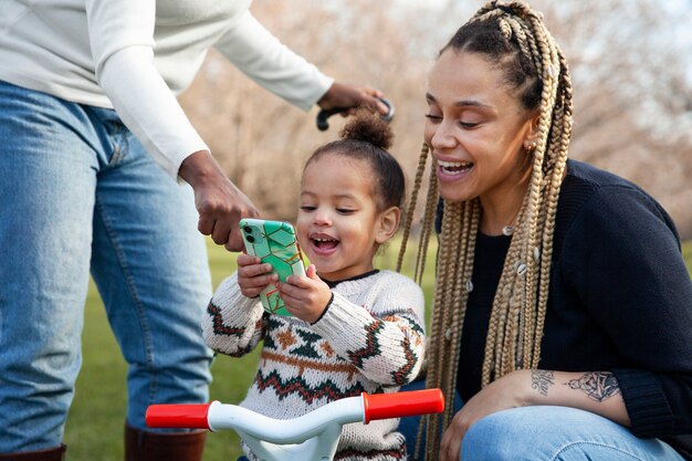 Niño sonriente y mujer mirando el teléfono inteligente