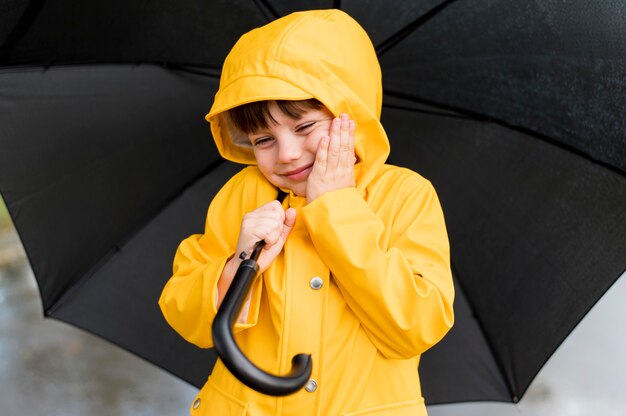 Niño sonriente con un paraguas abierto