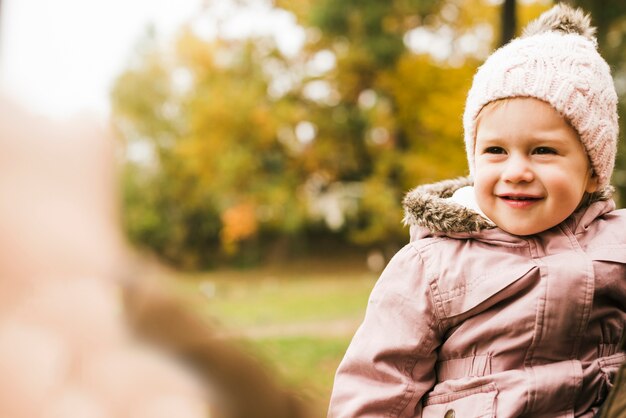 Niño sonriente en el parque de otoño