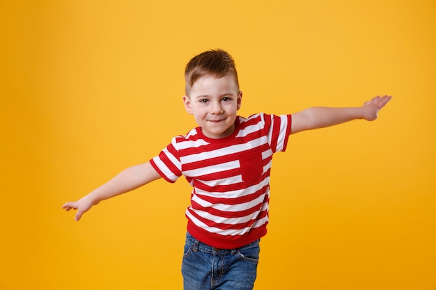 Niño sonriente de pie con las manos extendidas