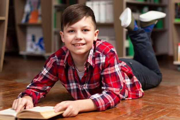 Niño sonriente en el piso leyendo