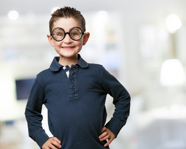 Niño sonriente posando con unas gafas falsas
