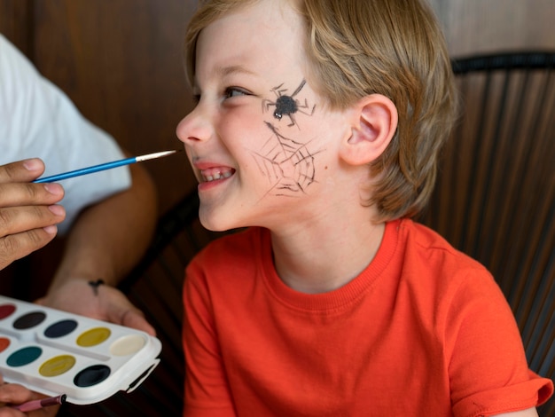 Niño sonriente de primer plano con la cara pintada para halloween