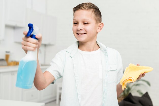 Niño sonriente con producto de limpieza