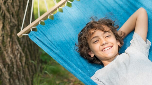 Niño sonriente sentado en hamaca