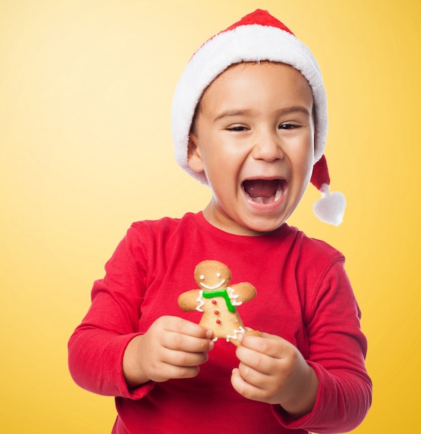Niño sonriente con su sabrosa galleta de jengibre