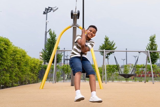 Niño sonriente de tiro completo al aire libre