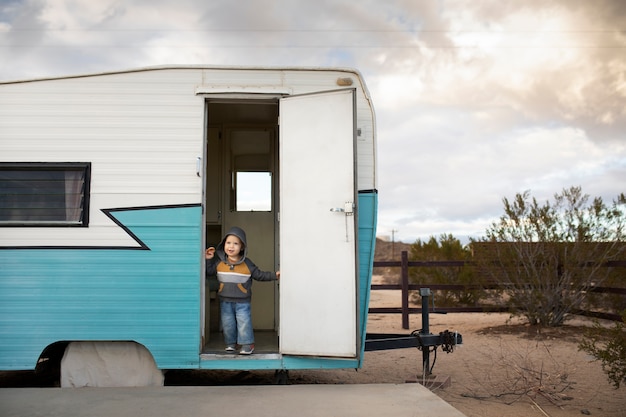 Niño sonriente de tiro completo en autocaravana