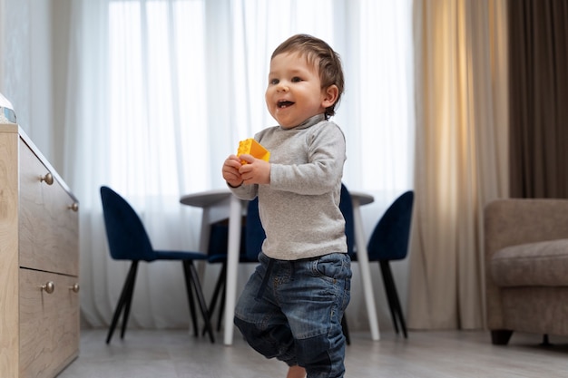 Niño sonriente de tiro completo dando sus primeros pasos