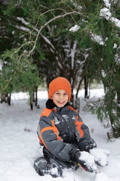 Niño sonriente de tiro completo con nieve
