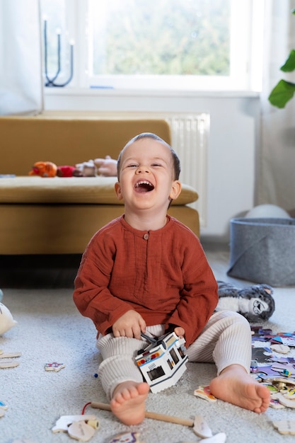 Niño sonriente de tiro completo reparando coche de juguete