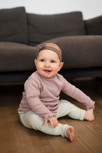 Foto gratuita niño sonriente de tiro completo sentado en el piso