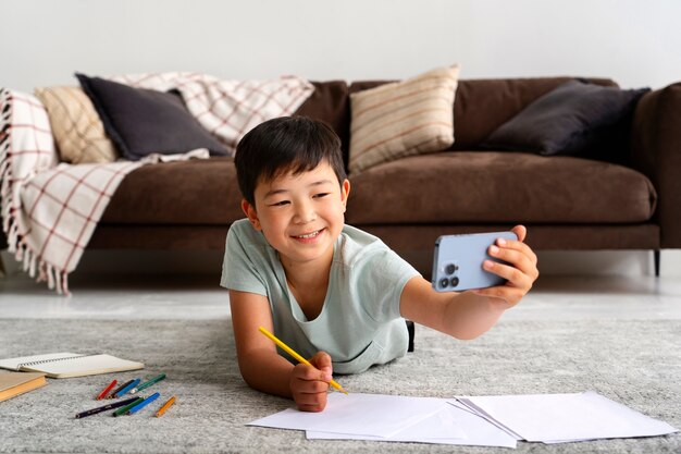 Niño sonriente de tiro completo tendido en el piso