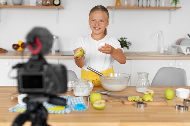 Niño sonriente de tiro medio cocinando