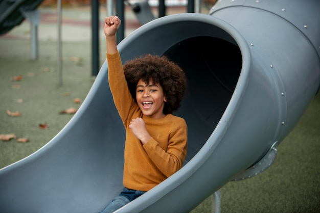 Niño sonriente de tiro medio en diapositiva