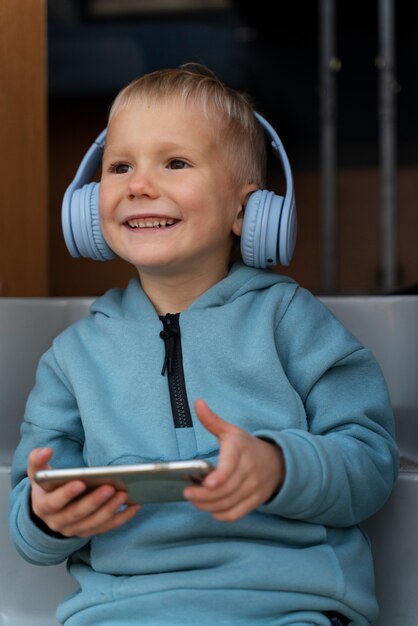 Niño sonriente de tiro medio con dispositivos