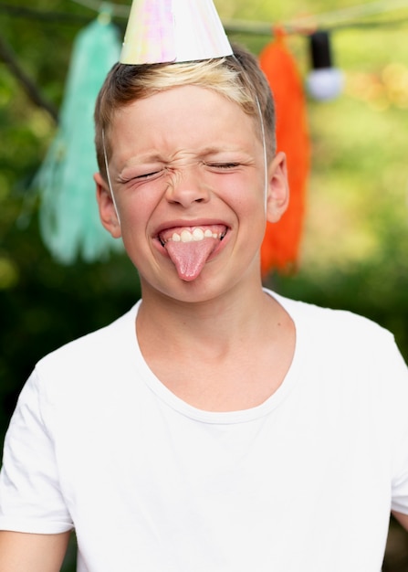 Niño sonriente de tiro medio con gorro de fiesta