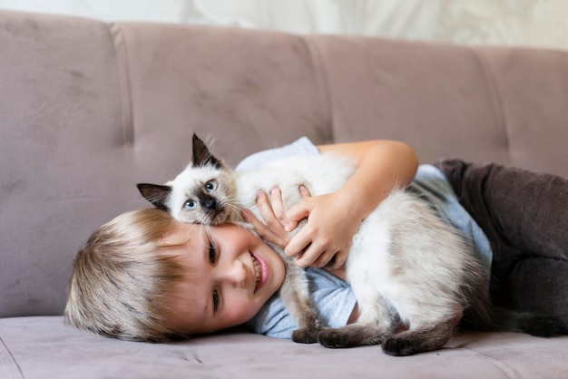 Niño sonriente de tiro medio con lindo gato