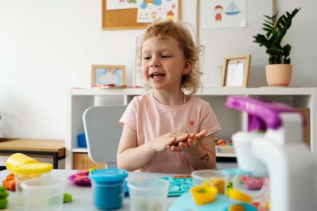 Niño sonriente de tiro medio en la mesa