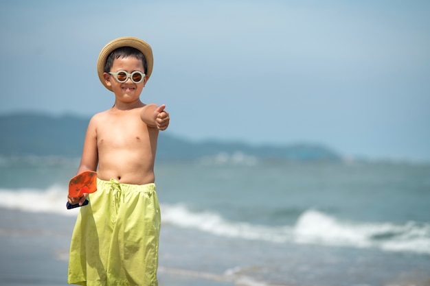 Foto gratuita niño sonriente de vista frontal en la playa