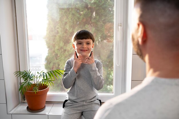 Niño sonriente de vista frontal sentado en el baño