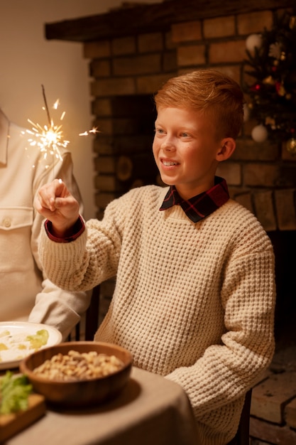 Foto gratuita niño sonriente de vista lateral con fuegos artificiales