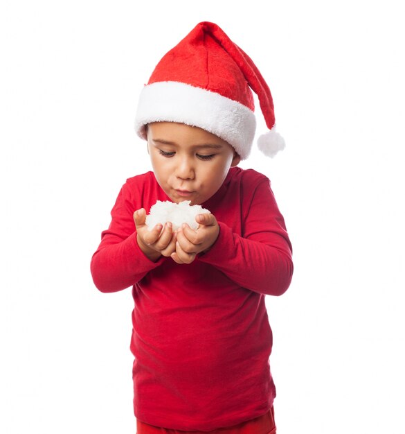 Niño soplando a la nieve