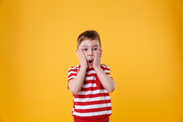 Niño sorprendido con las manos en la cara