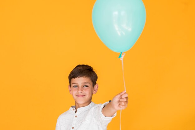 Niño sosteniendo un globo azul