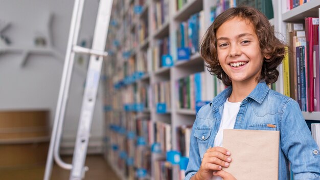 Niño sosteniendo un libro con espacio de copia