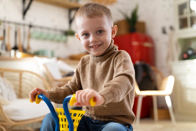 Niño sosteniendo manillar de triciclo tiro medio