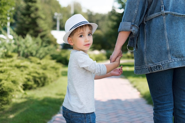 Niño sosteniendo la mano de su madre