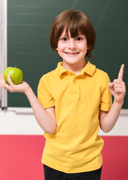 Niño sosteniendo una manzana verde