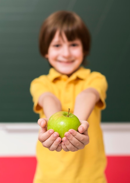 Foto gratuita niño sosteniendo una manzana verde